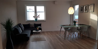 Monteurwohnung - Kühlschrank - PLZ 33334 (Deutschland) - Wohnraum mit Couch und Esstisch - netroom`S